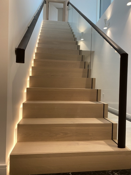 Leather fitted to oval handrails on wall mounted brackets and on glass balustrade