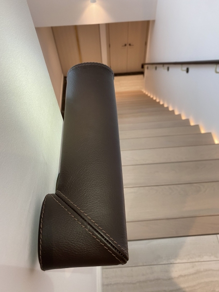 Stitching on ends and seam lines of oval leather handrail. Chelsea Creek project.