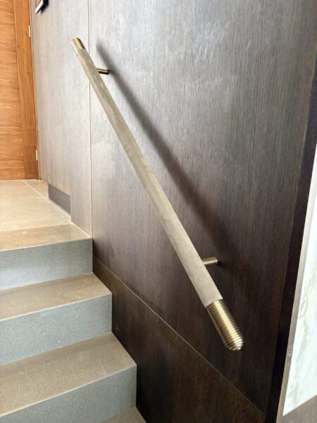 Solid brass finials on velour covered handrail.
