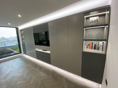 Wall to wall units with TV and lighting.