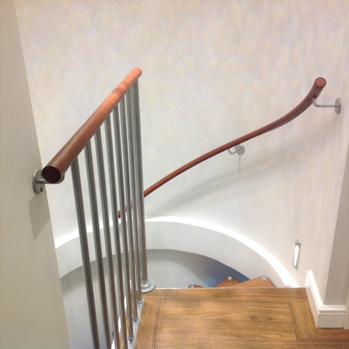 curving wall mounted leather handrail.