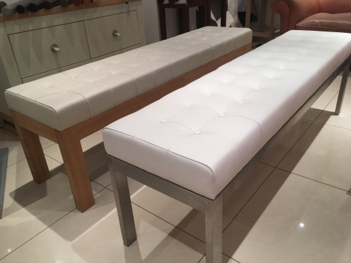 Deep button leather benches with oak and stainless steel frames.