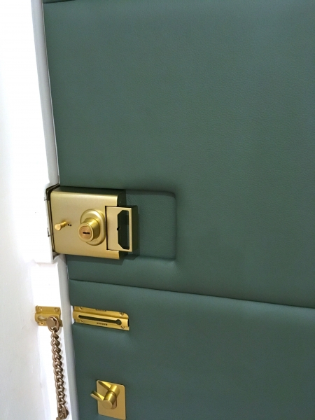 Leather applied to interior front door accommodating existing locks and handles.