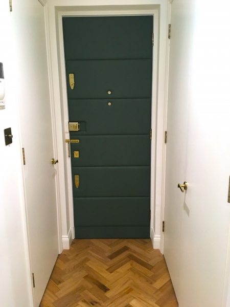 Leather panels applied to interior front door of London apartment.