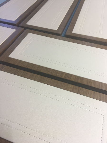 leather panels with stitch detail on drawer fronts.