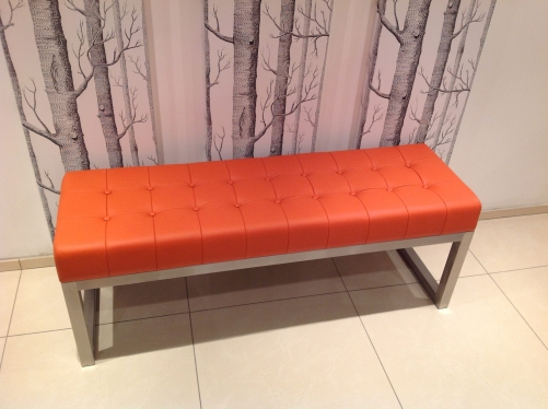 Statement 'orange' leather bench with padded 'deep button' effect seat and brushed stainless steel frame.