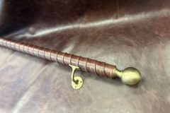 Brass finials and brackets selected by client to go with their aged leather tennis wrap handrail.