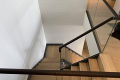 Continuous leather handrail on glass balustrade.