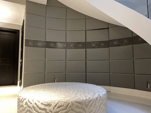 Curved leather panelled wall with concealed door.