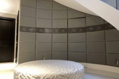 Curved leather panelled wall with concealed door.